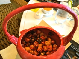 The red potful of Song of the Dragon Chicken with cute red peppers